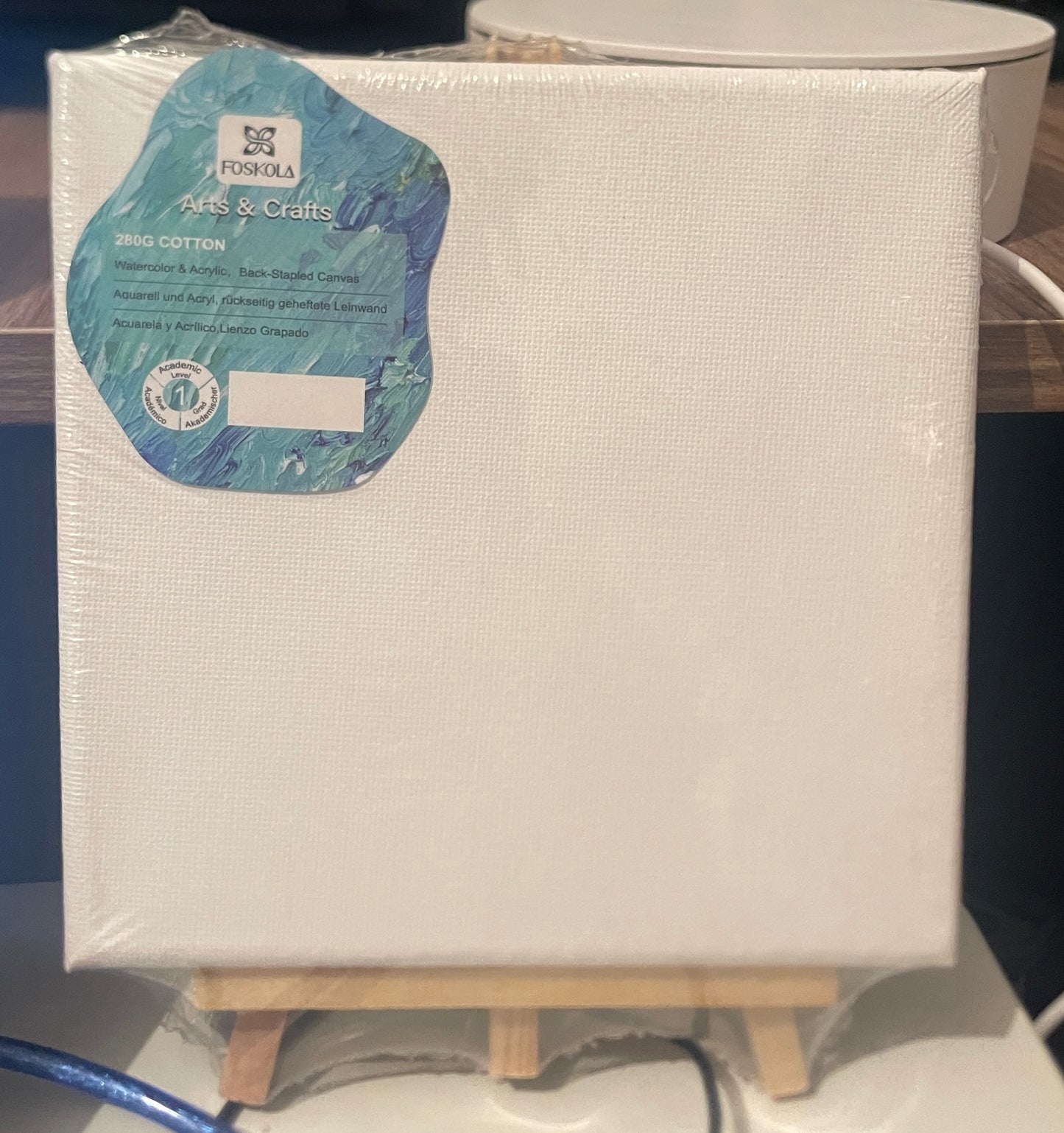 Blank canvas 15x15 with a small wooden easel against a neutral background