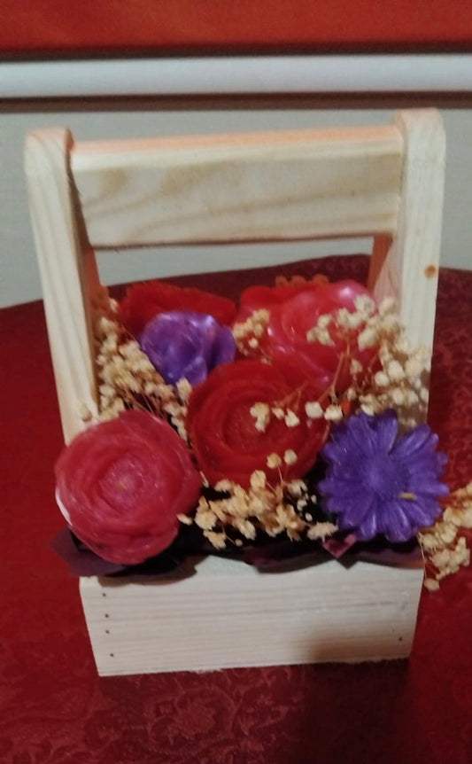 Decorative arrangement with red and purple Soap in a wooden basket on a red surface.