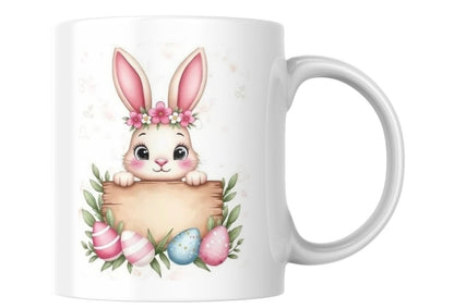 White mug with a bunny design holding Easter eggs on a white background