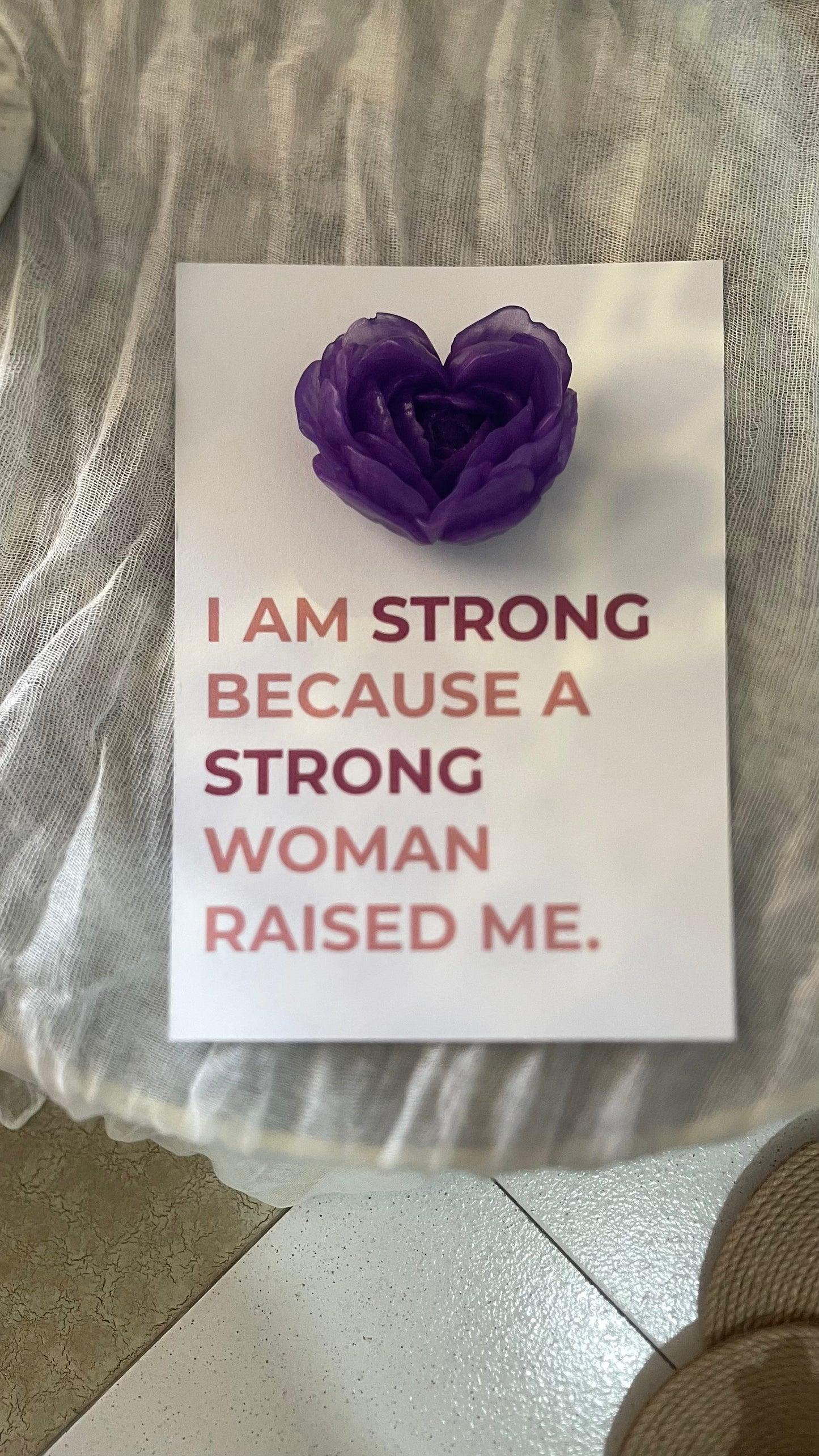 Card with purple heart-shaped object and motivational text on a neutral background